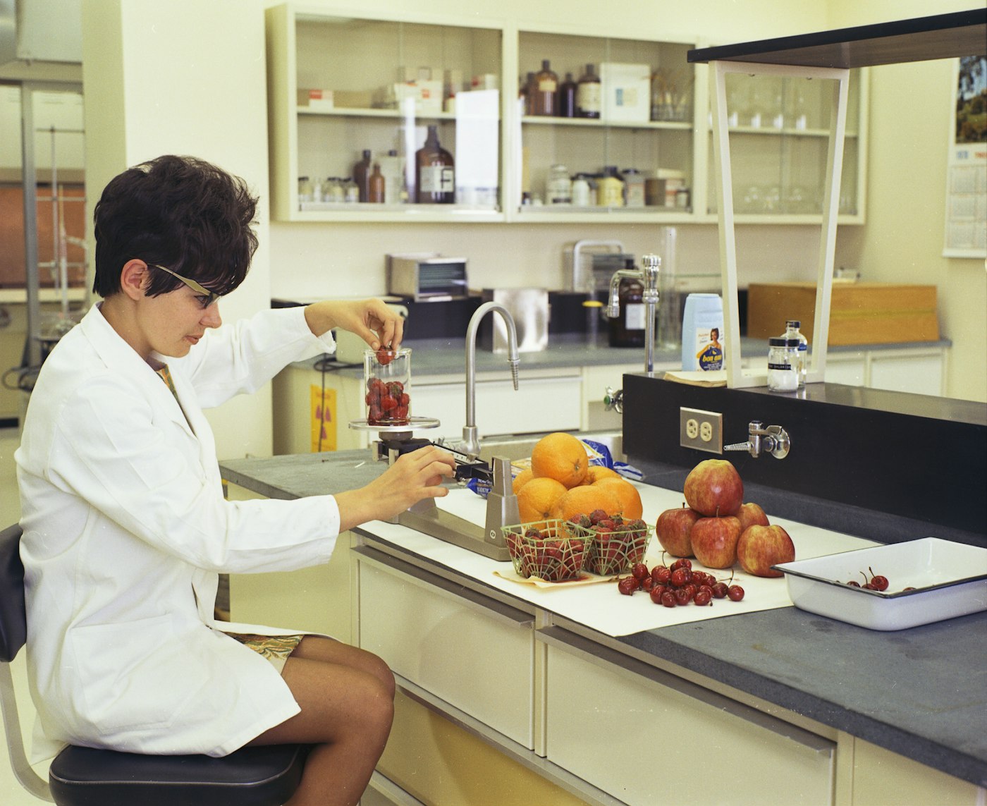 A technician working at a laboratory bench in a white coat.